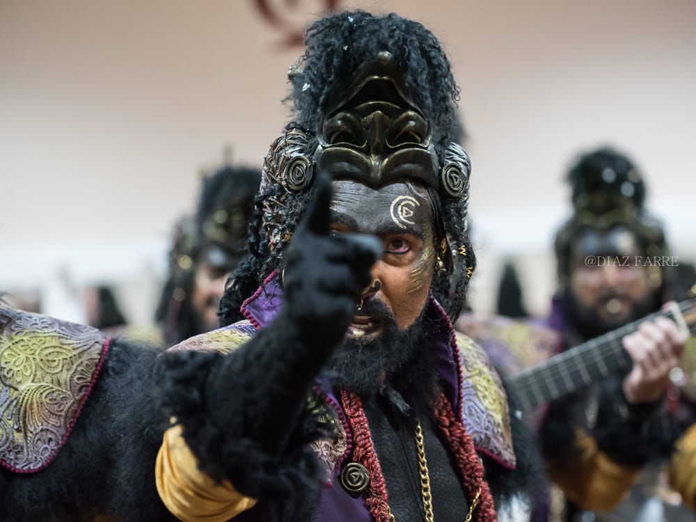 Martinez ares disfrazado de oveja negra señalando con el dedo en primer plano hacia el objetivo